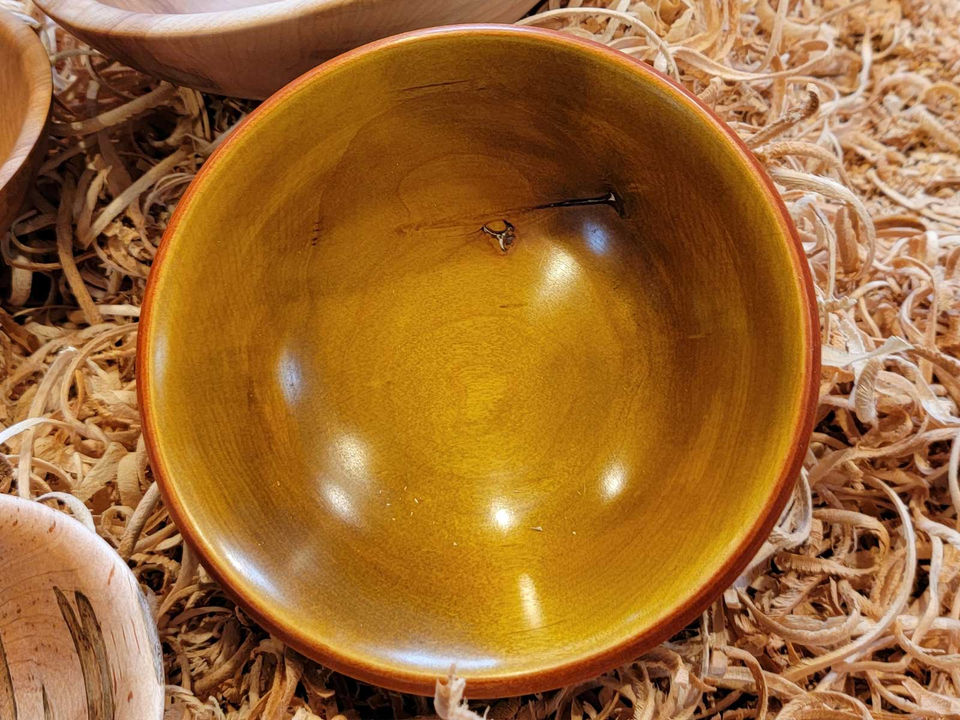 A polished and colored wooden bowl, seen from above
