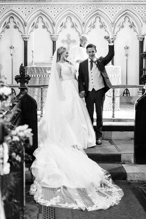 black and white image of bride and groom celebrating at church wedding