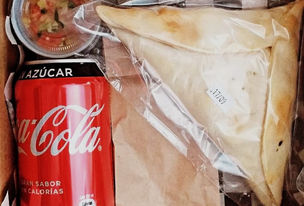 Novobox con empanada Napolitana veggie, sopaipillas con pebre, dulces chilenos, bebida.