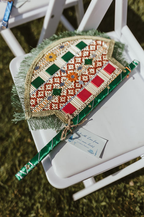 Handmade fans made by relatives in Pakistan are given to guests for outdoor wedding ceremony