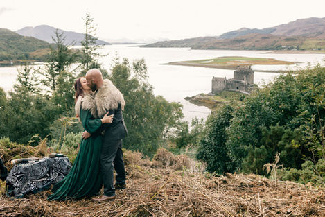 Bride and groom share a just married kiss during their wedding ceremony with Eilean Donan Castle in the background