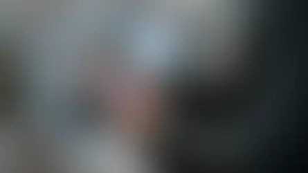 Person in suit uses a tablet outdoors with blue digital icons like gears and shipping symbols floating around, indicating tech focus.