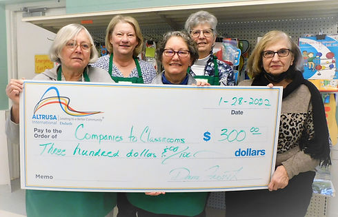 Companies to Classrooms Duluth volunteers hold a check worth 300 dollars