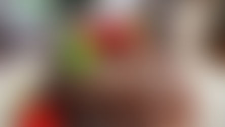 A rich chocolate cake adorned with fresh strawberries and mint leaves sits on a decorative plate, set against a cozy kitchen background.