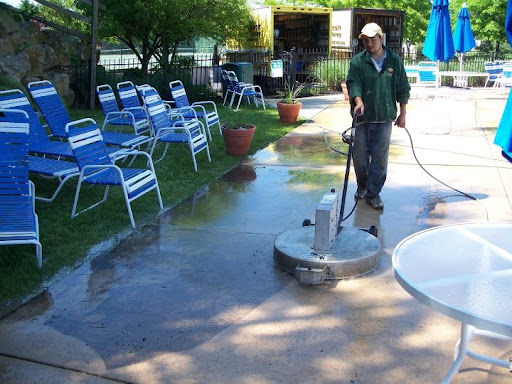 Man pressure washing by pool side