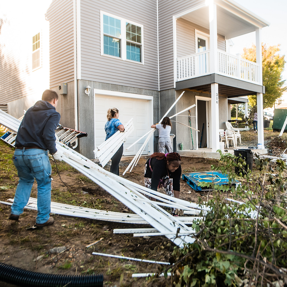 A group of volunteers work on fixing up a house.