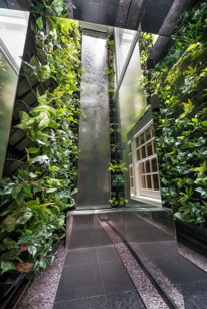 Indoor Oasis: A tranquil waterfall and lush green walls bring a harmonious touch of Feng Shui and elegance, enhancing mindfulness in a serene, inspired  meditation space.