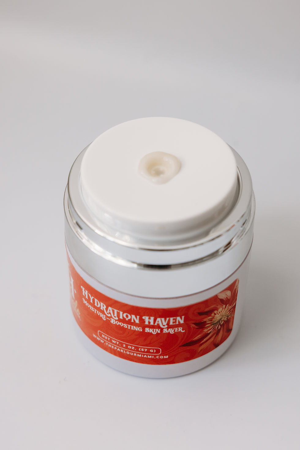 White skincare jar with red label reading HYDRATION HAVEN on a clean white background.