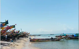 Aerial view of sandy coast with salt basins and fishing boats.