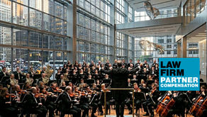 A full orchestra and choir perform in a glass-walled atrium beneath suspended sculptural owls, with a blue "Law Firm Partner Compensation" graphic overlay.