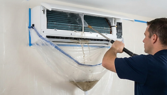 Professional mini split deep cleaning using a bib kit bag system to pressure wash mold and debris from the indoor blower wheel.