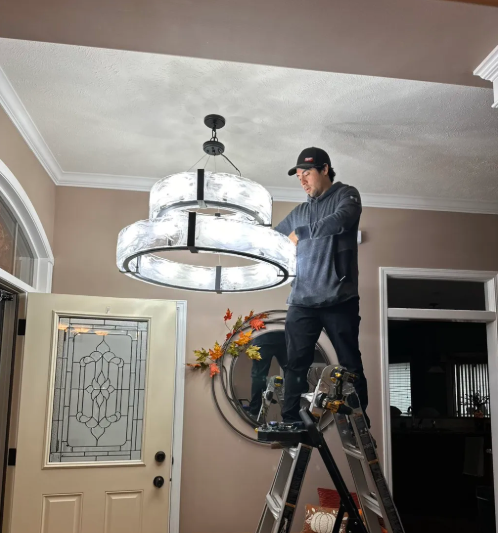 Fit It Right Handyman Services installing a chandelier light fixture in an Omaha, NE home entryway