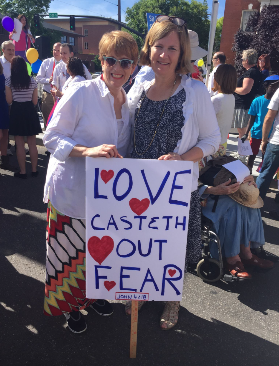 Erika and her cousin Gigi hold a poster reading "Love Casteth Out Fear"