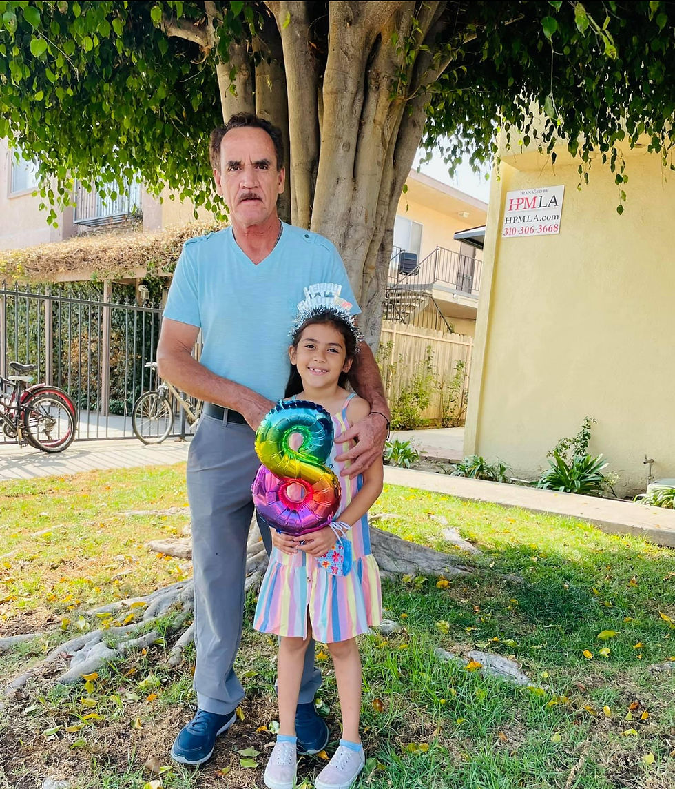 Felipe and his daughter Kelly celebrate her 8th birthday with a colorful balloon under a shady tree.