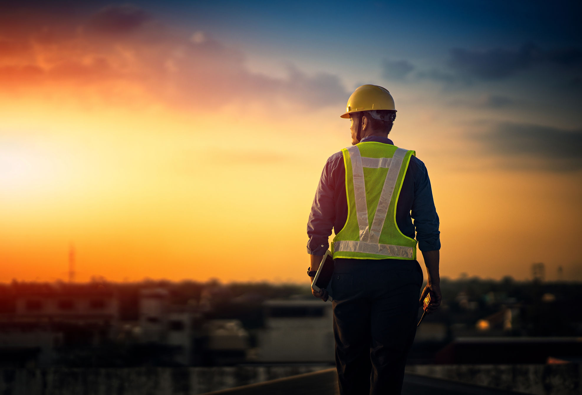 Engineer on a construction site at sunset. Working on the roof . .jpg