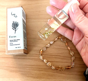 Roll-on bien-être et bracelets en pierres naturelles, outils holistiques utilisés en séance.