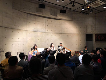 イベントステージで話す人々と観客、女性たち。演奏依頼。