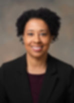 Portrait of Courtney Galiber smiling professionally wearing an all black dress suite