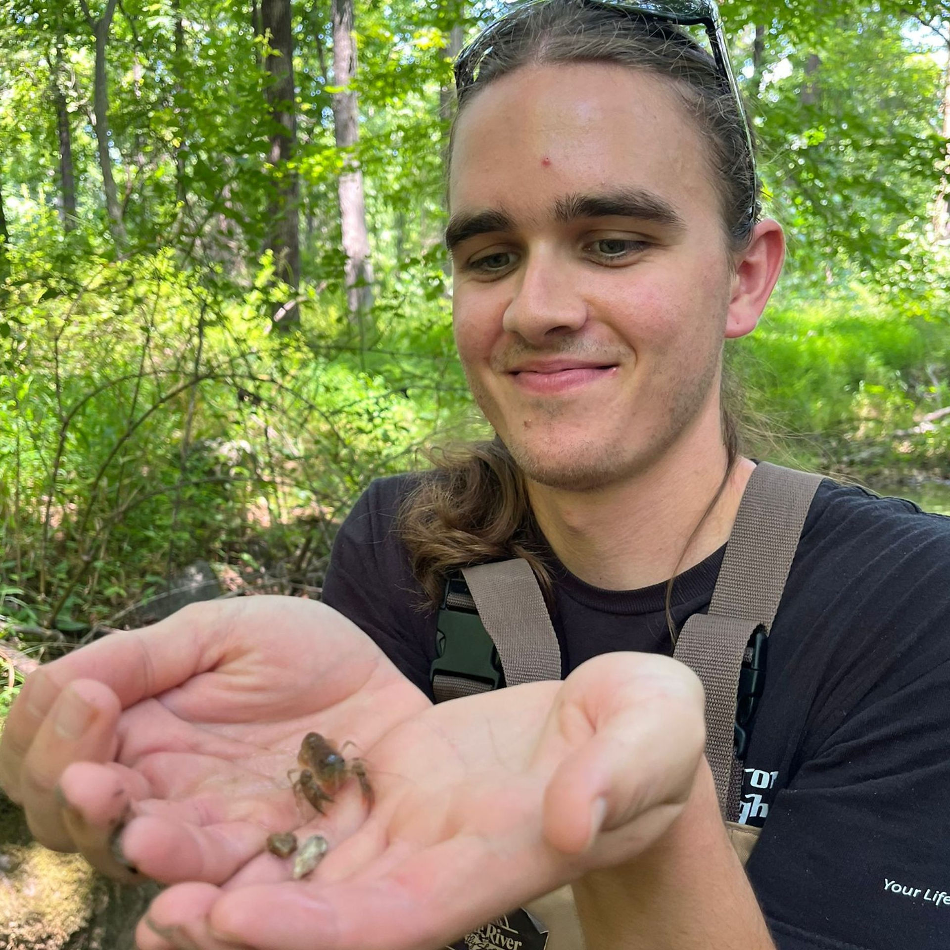 young man holds  wildlife in his hands