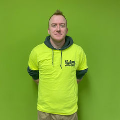 man with short hair and hi vis shirt smiling with lime green background
