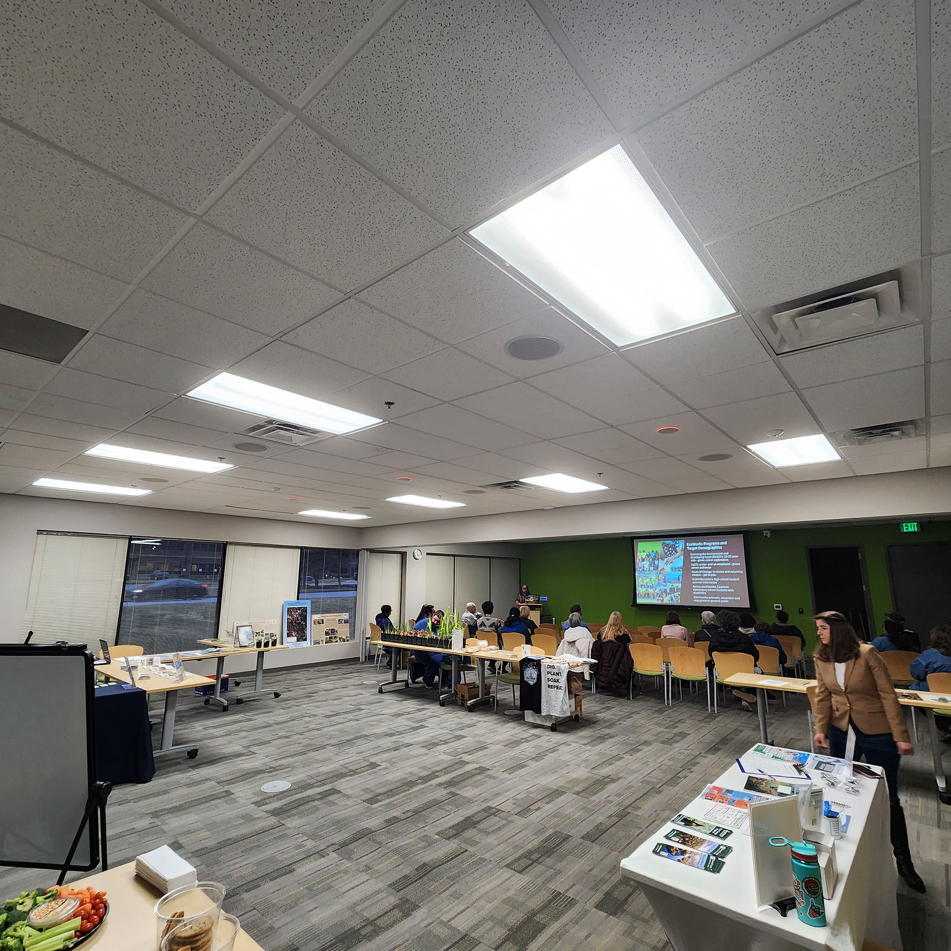 view of entire room during open house night, with our tables, plant sale and people sitting in for the learning