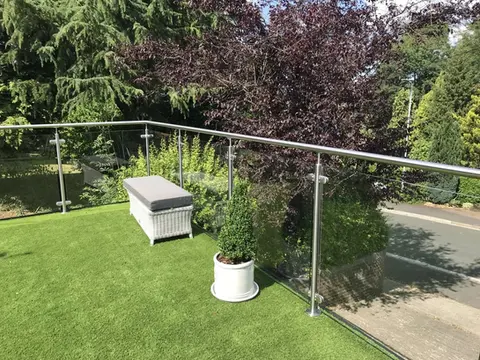 Glass balustrade surrounding grass area