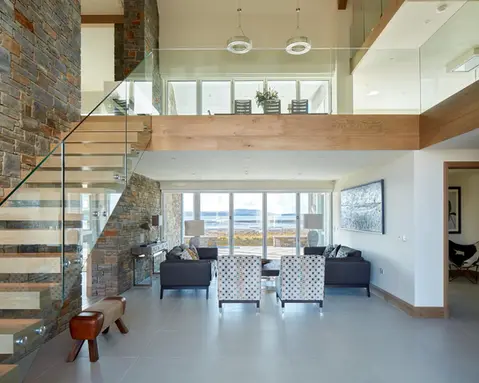 Open plan living space with staircase and glass balustrades