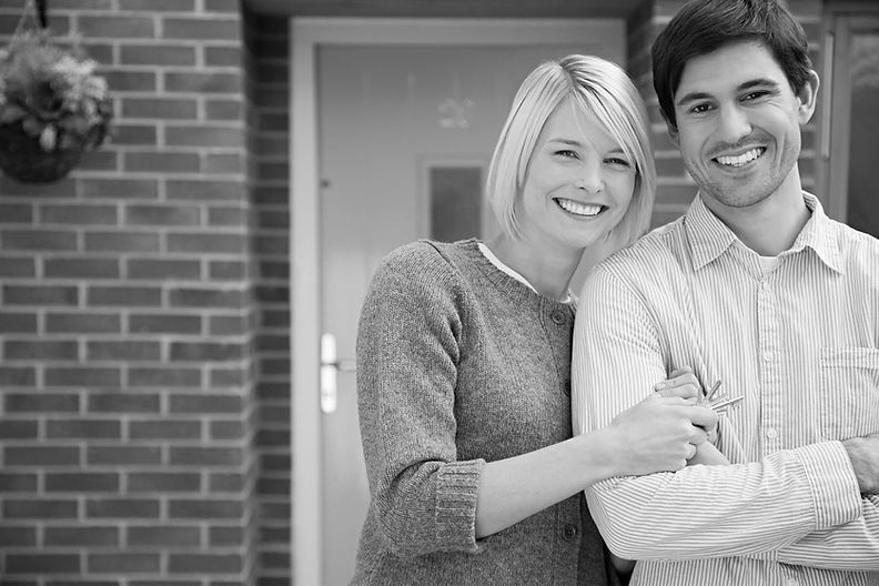 A couple standing in front of their new home