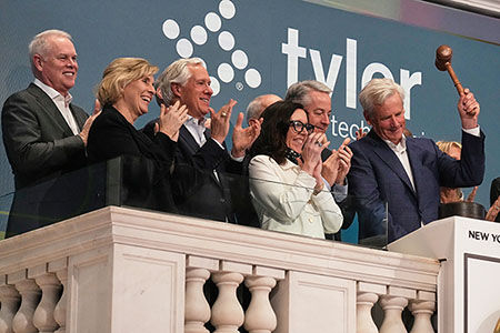 (Above) While 87,000 Cook County taxpayers remain stranded by a system-wide software backlog, Tyler Technologies Chairman John Marr celebrates corporate success by ringing the closing bell at the New York Stock Exchange on February 3, 2026. The Texas firm’s unresolved county tech contract has left an estimated $46 million in local refunds bottlenecked. (AP Photo/Richard Drew)