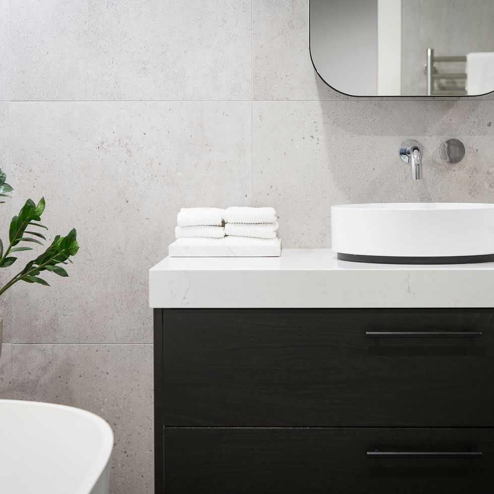 Modern bathroom sink with towels and plant on a white countertop setting.