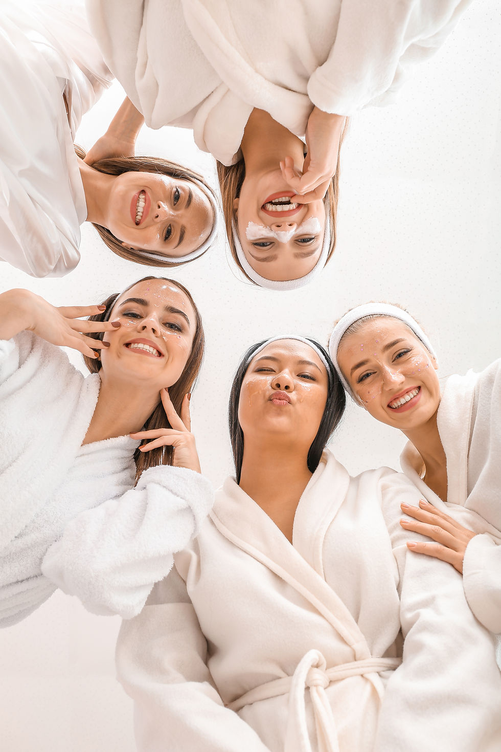 Five women in bathrobes looking down, some with eye masks