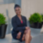 Smiling woman in a dark suit sitting
