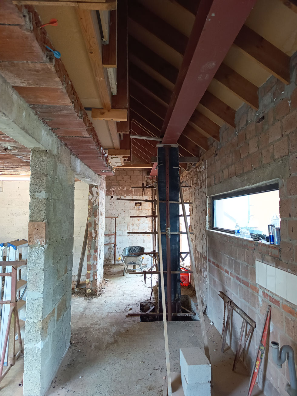 Wat eerst de garage was zal nu worden opengewerkt. Safety en stabiliteit zijn key, vandaar eerst het plaatsen van de nodige structurele elementen op het bestaande hellend dak te ondersteunen vooraleer de afbraakwerken van start gaan. 2 stalen liggers over de volledige lengte afsteunende op drie welgeplaatste kolommen verankeren de nieuwe uitbreiding voor de zorgwoning.