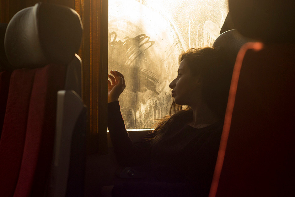 backlighting portrait of girl looking out of bus window