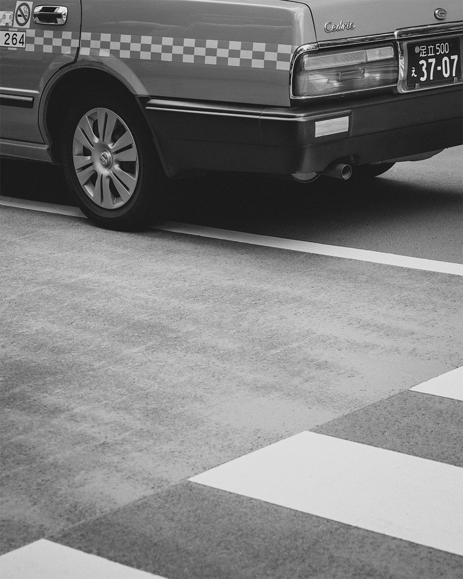 monochrome city photography car stopped next to pedestrians crossing
