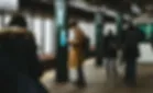 guy looking at smartphone on subway station