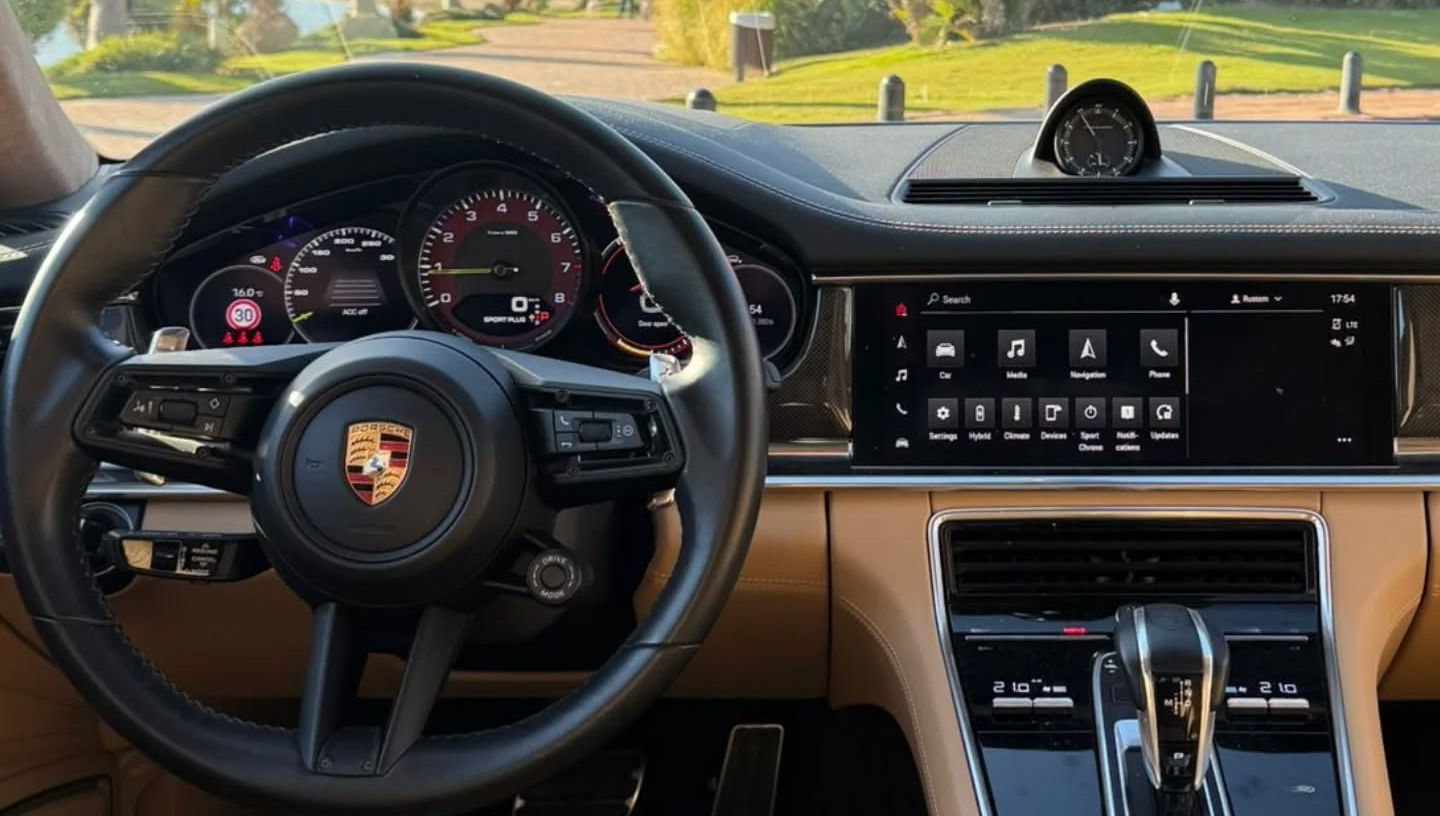 Driver-focused cockpit of Porsche Panamera 4 featuring digital instrument cluster, central touchscreen and sporty steering wheel, high-tech interior Porsche hire Marbella
