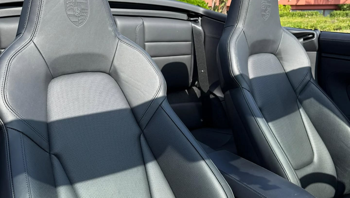 Front sport seats of Porsche 911 Carrera 4 GTS Cabrio with leather or Alcantara upholstery and integrated headrests.