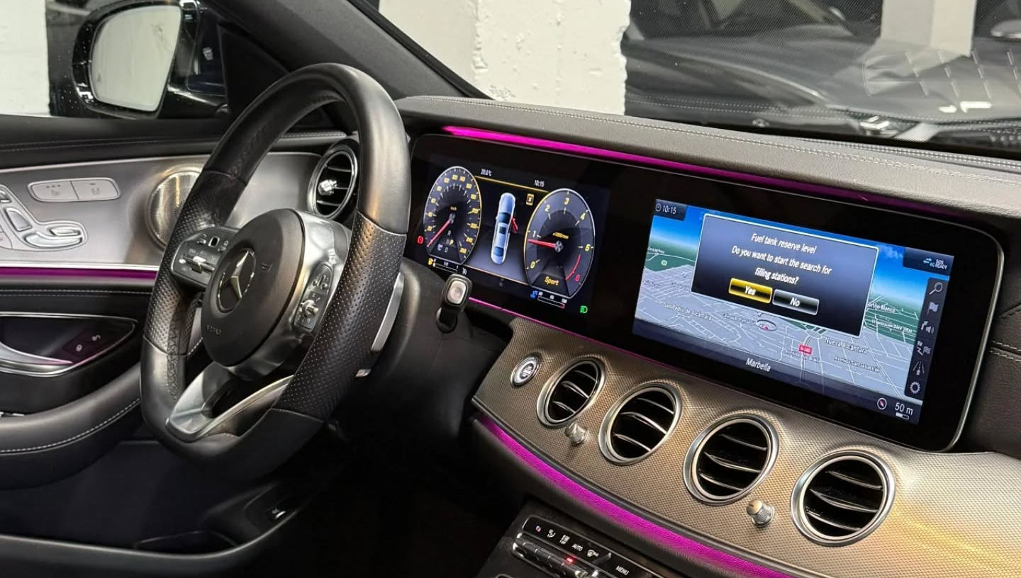 Modern cockpit of Mercedes E220d with digital instrument cluster, central infotainment screen and multi-function steering wheel, luxury interior Mercedes rental Marbella