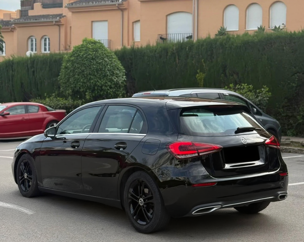 Rear left three-quarter hero view of Mercedes-Benz A180d showing LED tail lights, tailgate and rear bumper design.