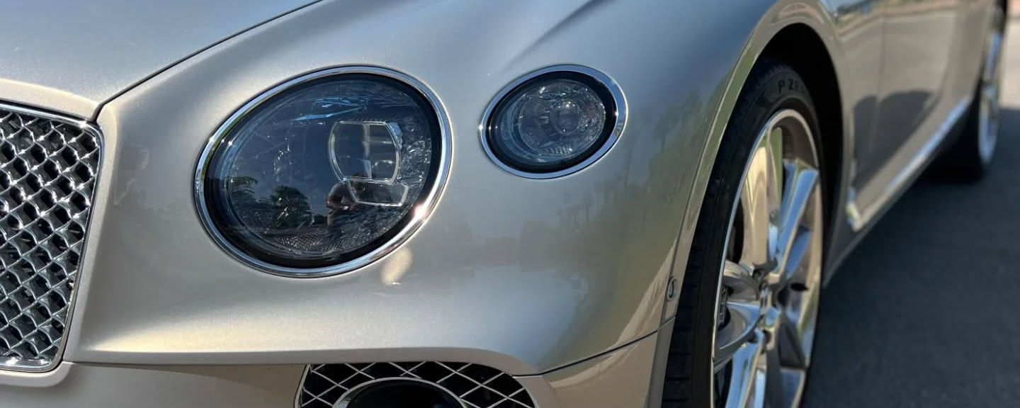 Front headlight detail of Bentley Continental GT luxury rental car
