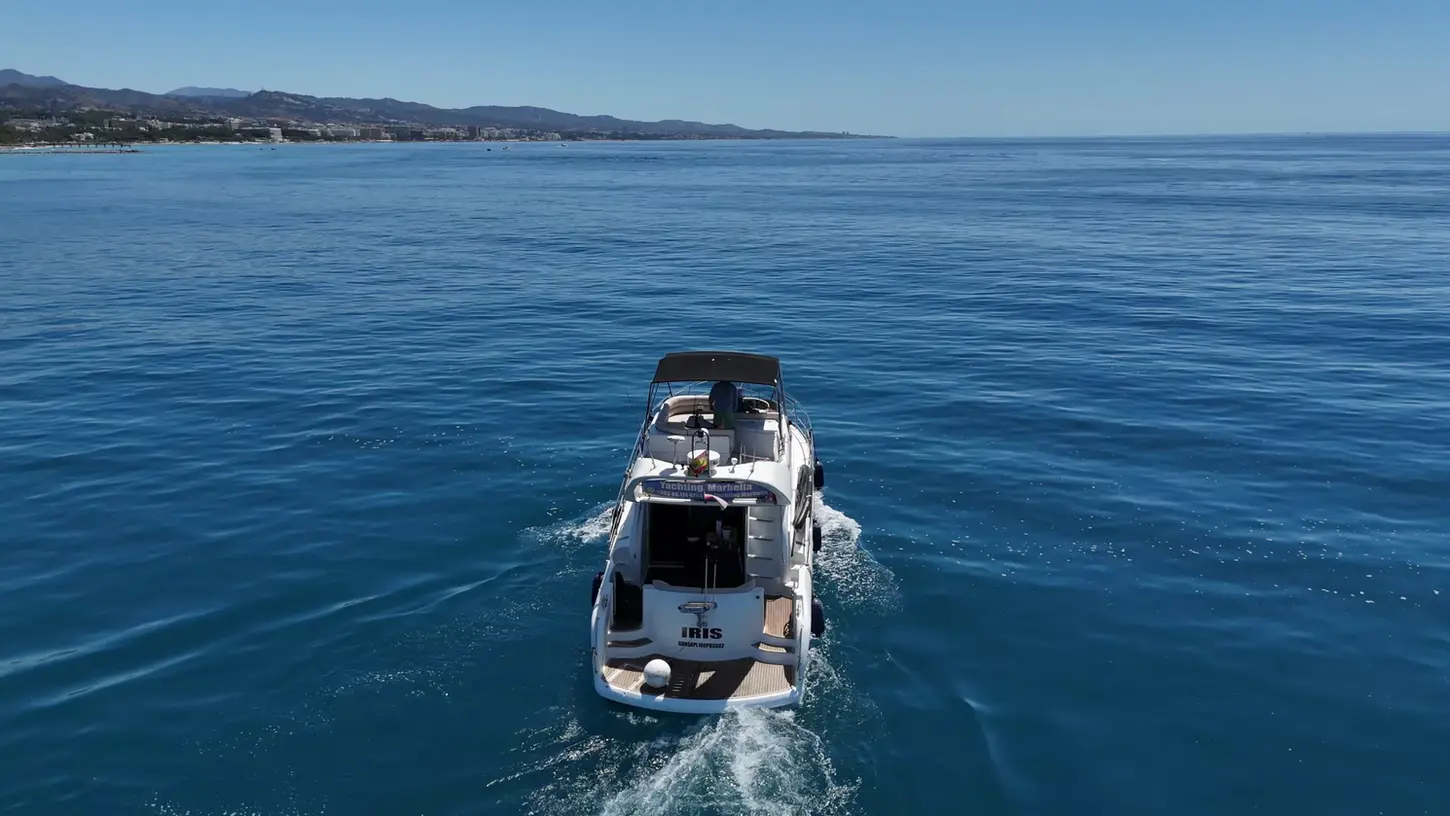 Aerial view from behind of a luxury yacht sailing off the Costa del Sol, ideal for Marbella yacht charter and day cruises.