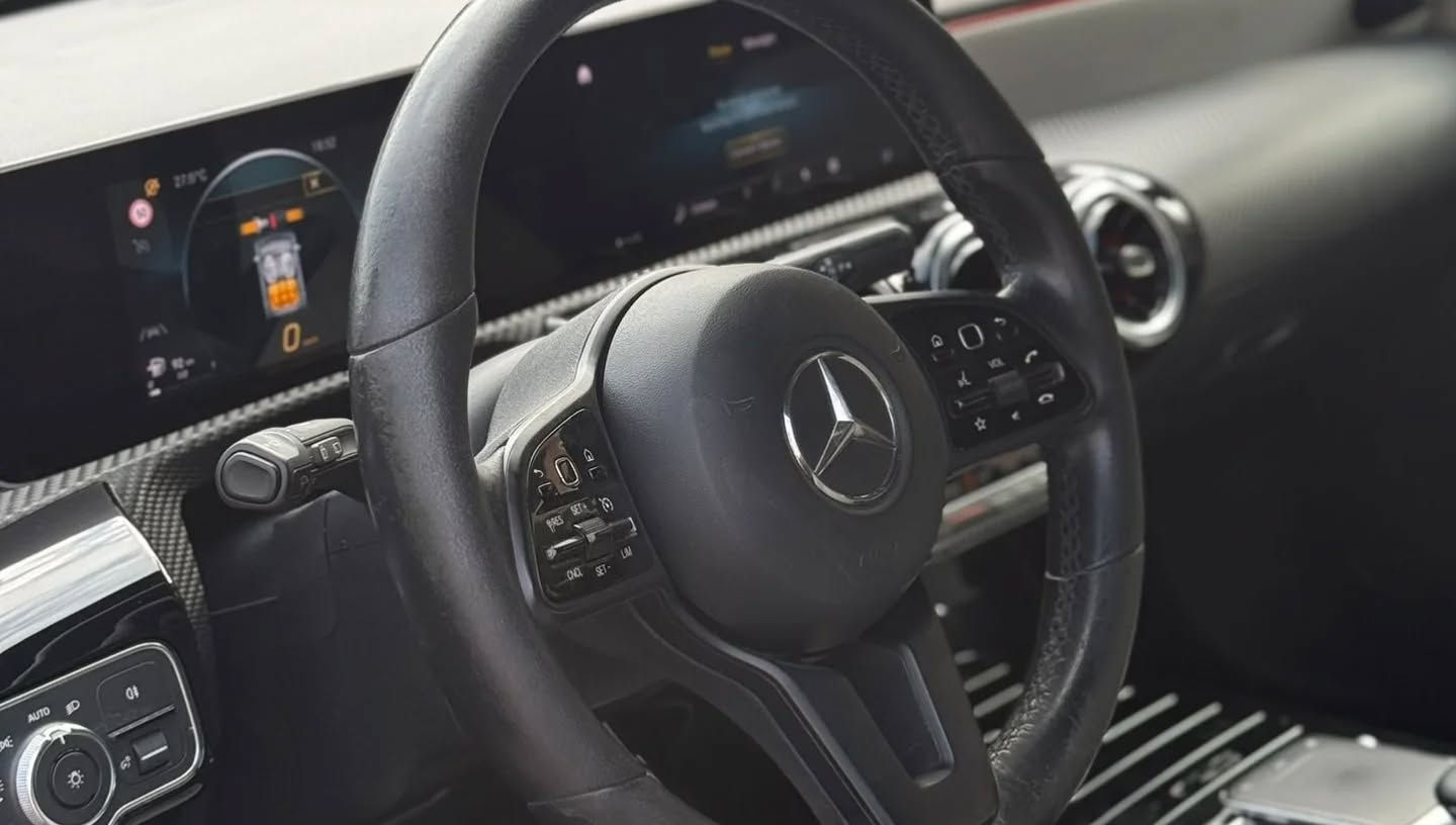 Dashboard of Mercedes-Benz A180d with digital instrument cluster, central screen and modern compact interior design.