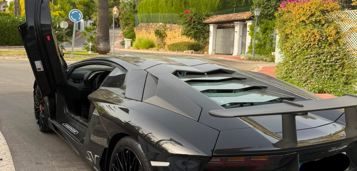 Rear three-quarter view of the black Lamborghini Aventador SV 800hp showing the SV graphics, rear wing and aggressive diffuser.
