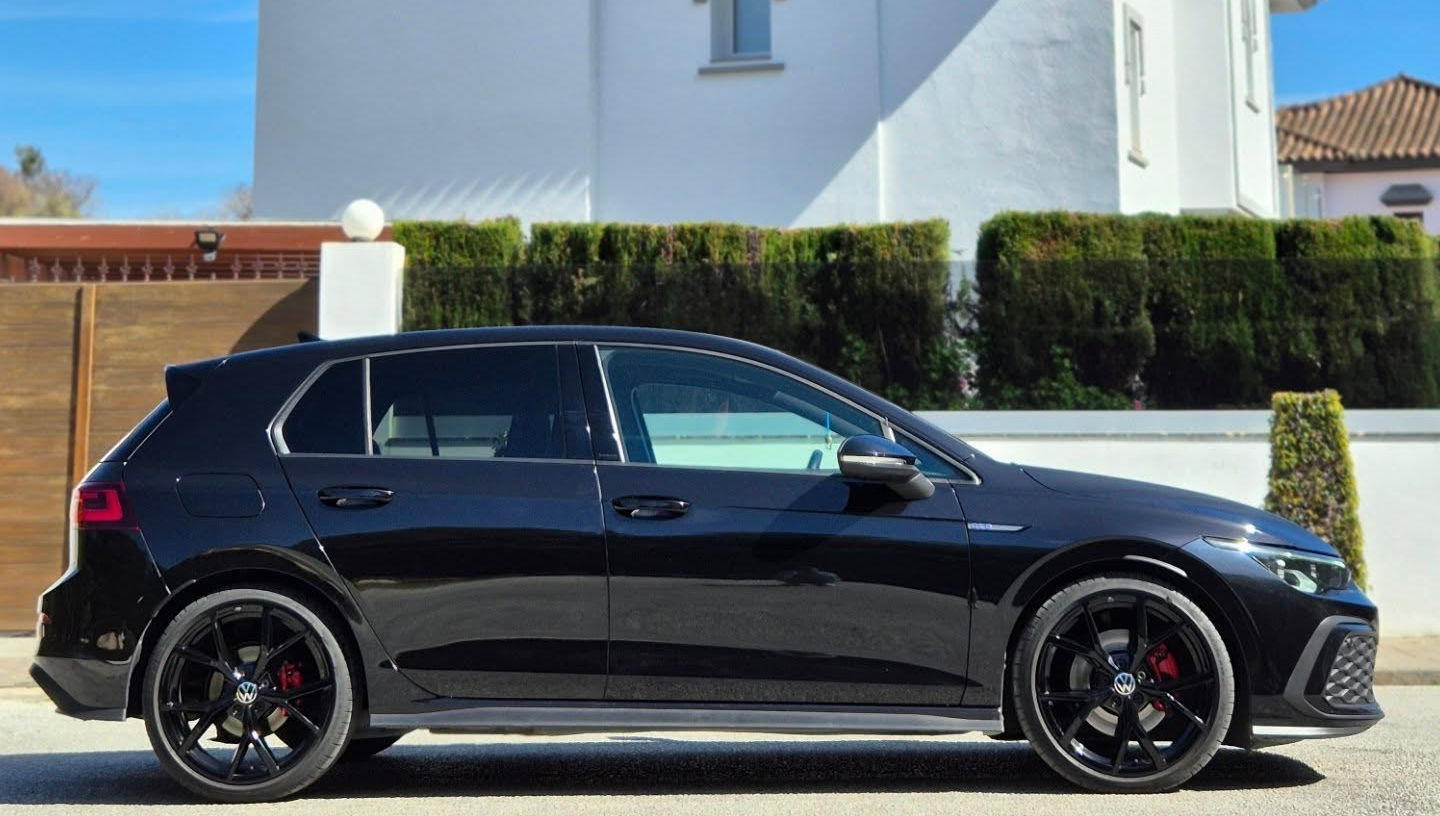 Right-side profile of black VW Golf GTD showing compact proportions, tinted windows and subtle side skirts, everyday hot hatch rental in Marbella