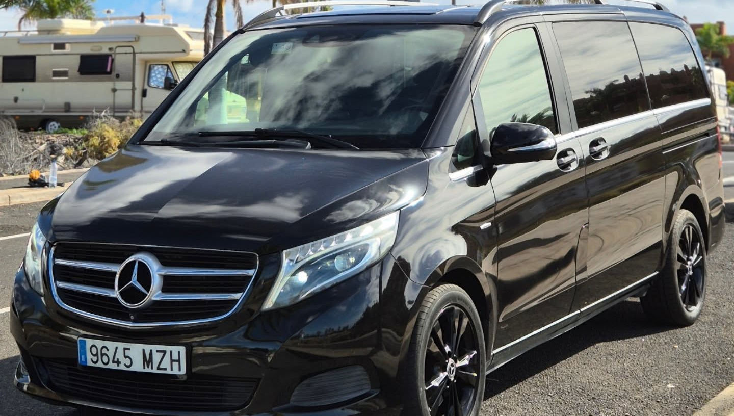 Front-left three-quarter hero shot of black Mercedes V250 with prominent Mercedes star grille, sculpted bonnet and executive van stance, luxury minivan rental Marbella