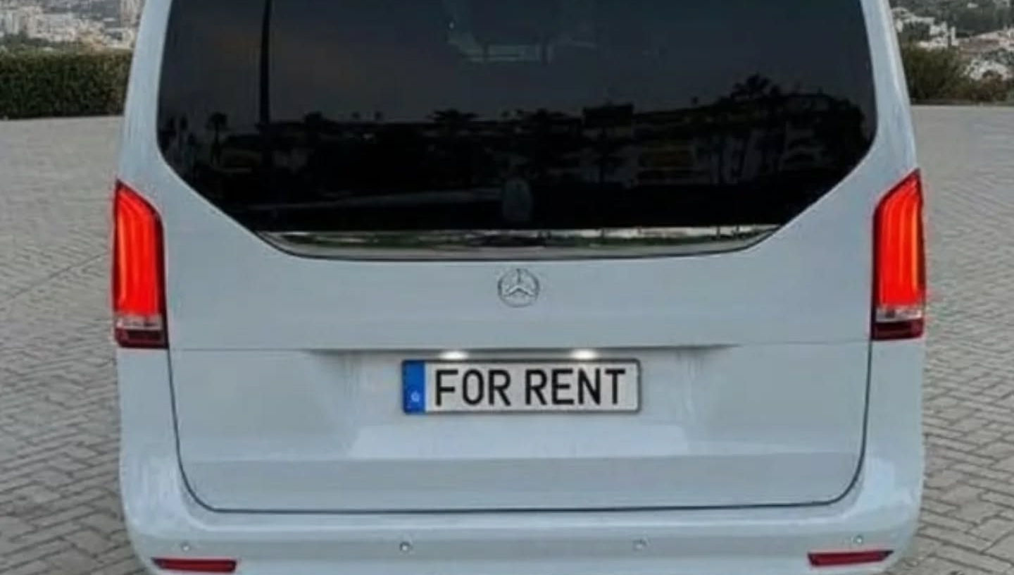 Straight rear view of white Mercedes V300 featuring large tailgate, rear window and clean bumper design, airport transfer van rental Marbella