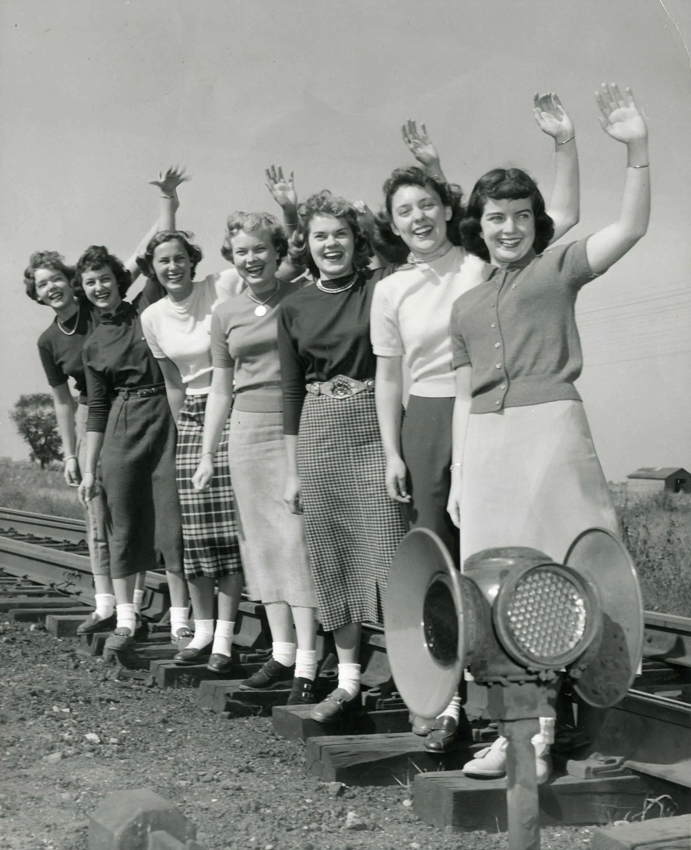 Row of ladies form the 40's or 50's black and white waving. A classic line up of white women from the Silent Generation