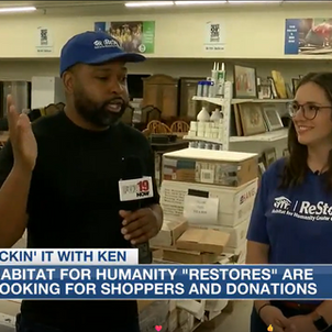 Two people in a retail store. One is holding a microphone.