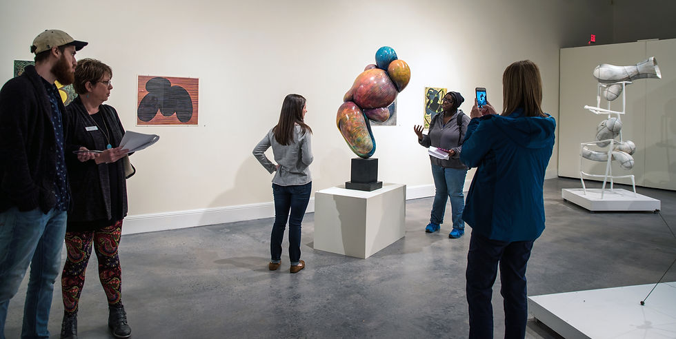 a group pf people viewing and taking photos of contemporary abstract sculpture at a solo exhibition by the artist Ralph Paquin